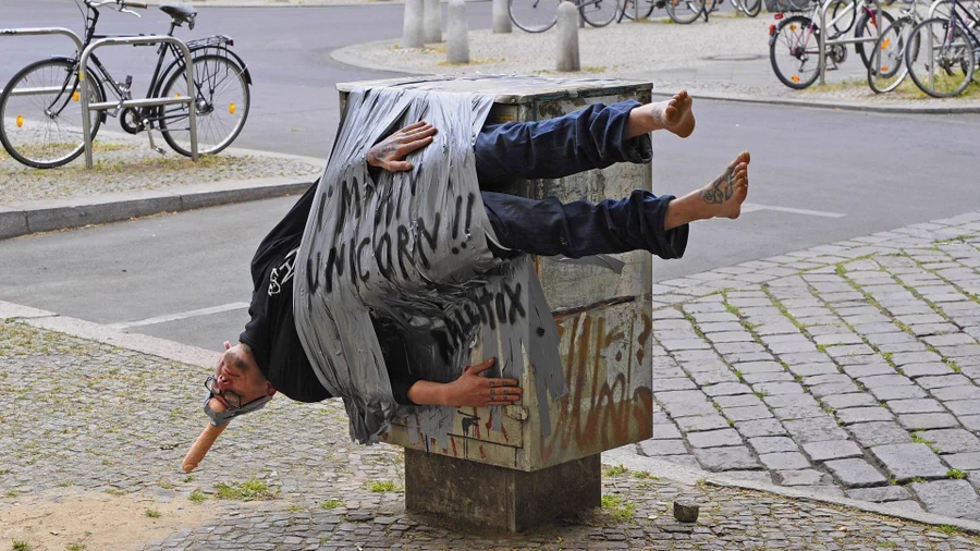 bdsm public humiliation, man taped to power box with dildo on his head