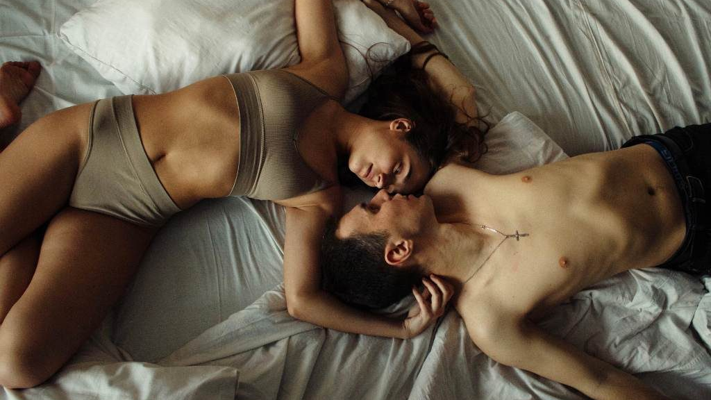 man and woman in underwear in bed